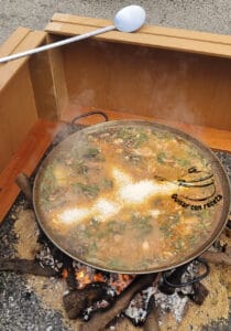 Concurso de paella añadiendo el arroz en tira